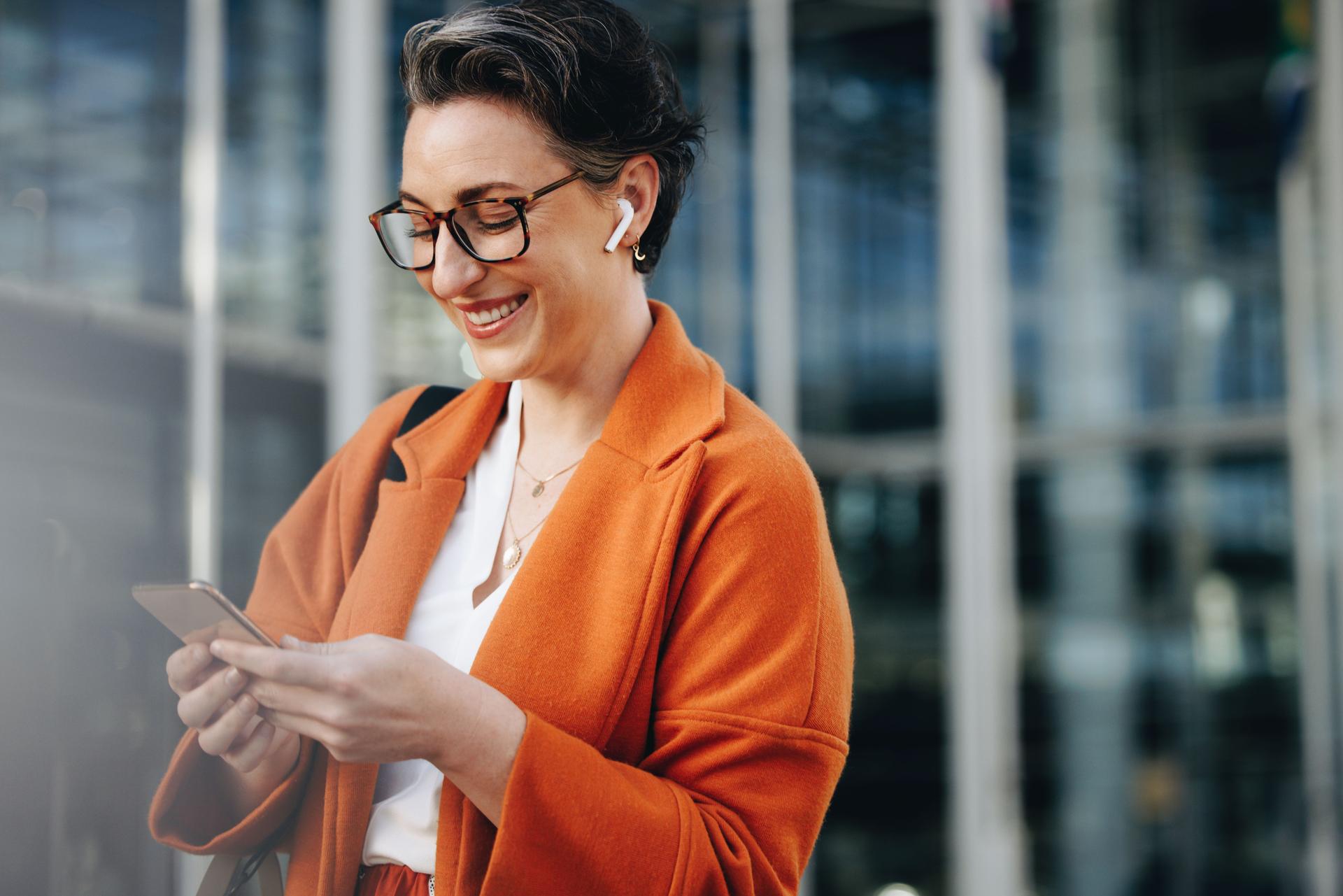 Smiling businesswoman reading a text message on her phone