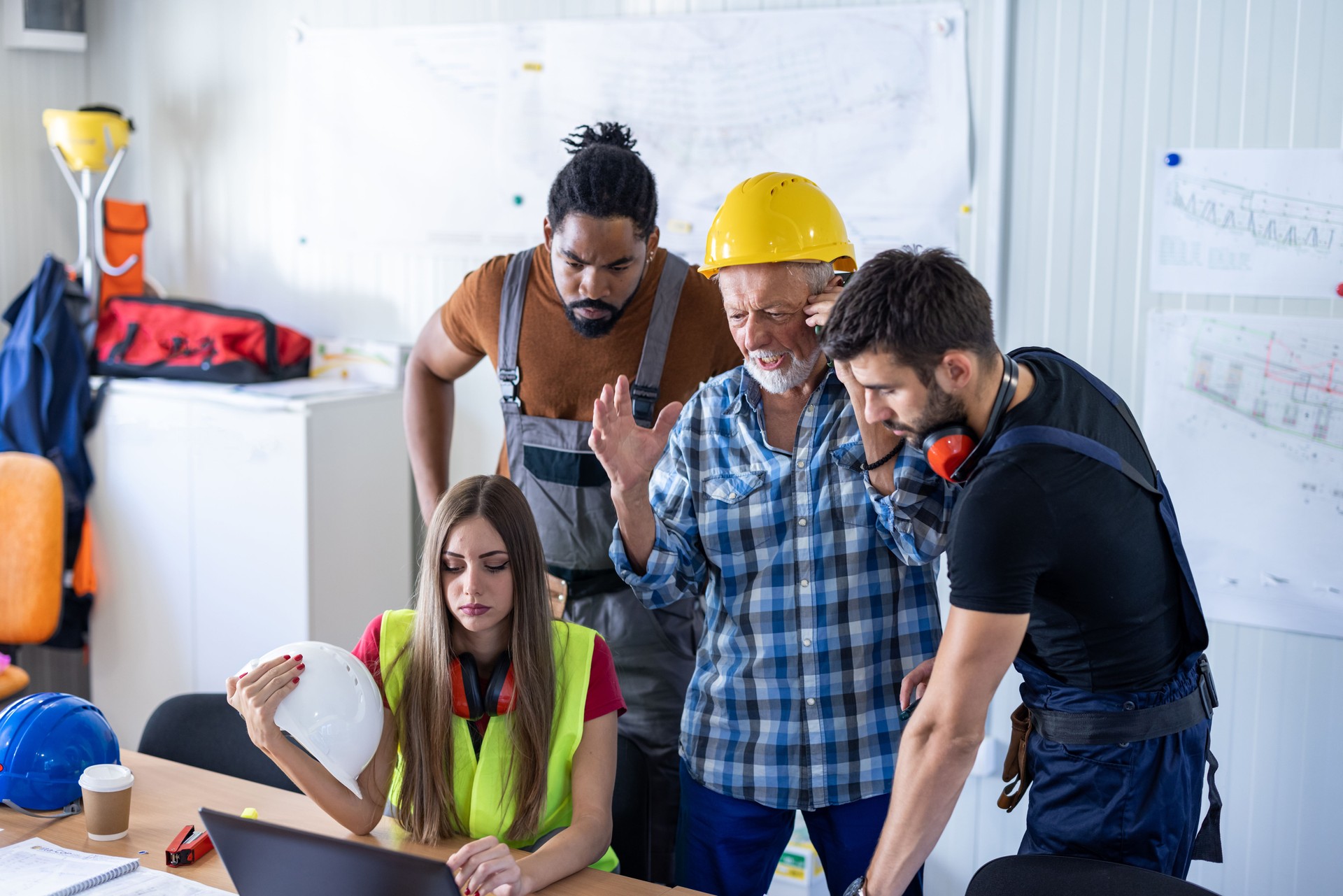 Young Construction Workers and Their Senior Colleague are Analyzing Construction Plans in the Office.