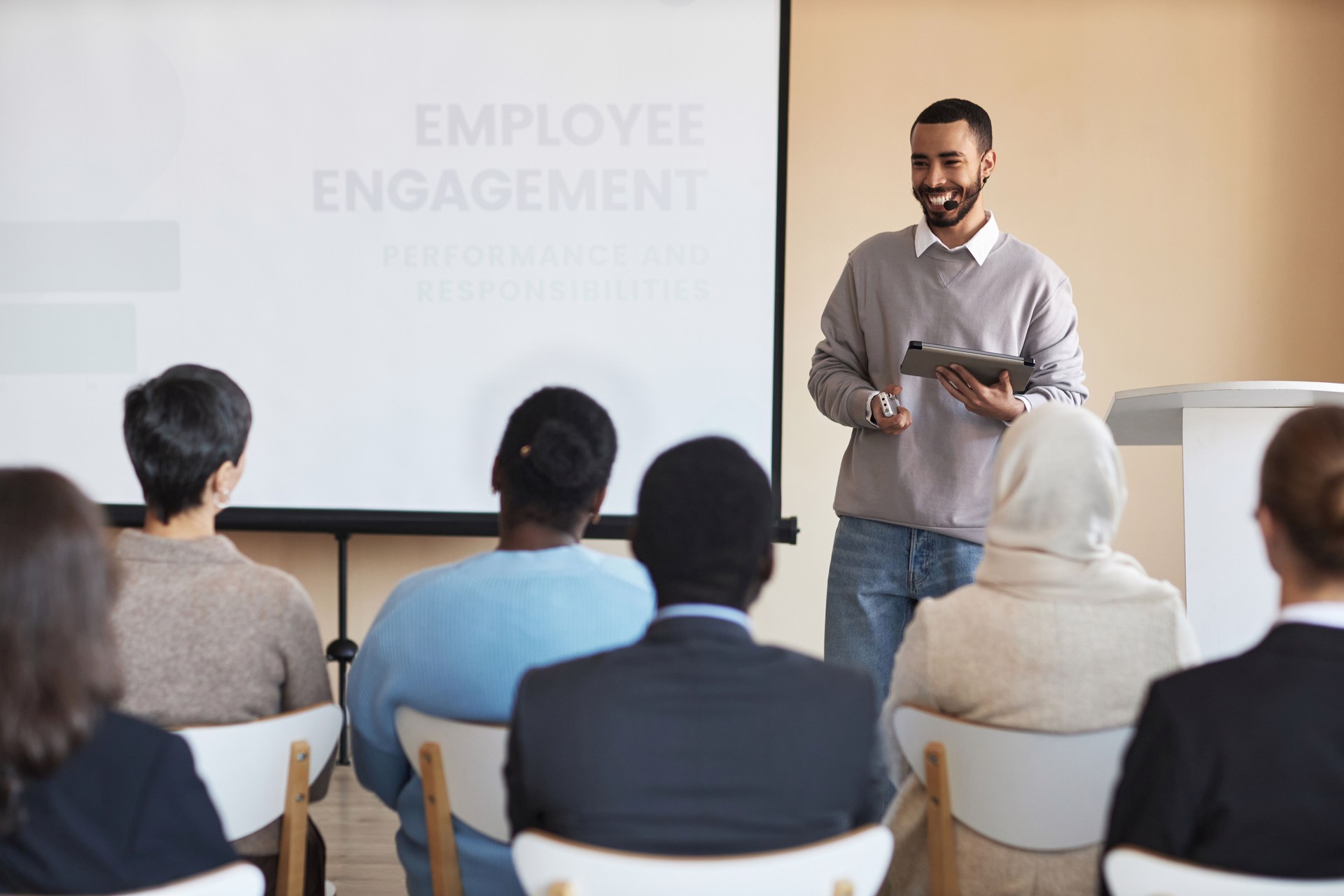 Young cheerful HR manager with tablet looking at one of employees