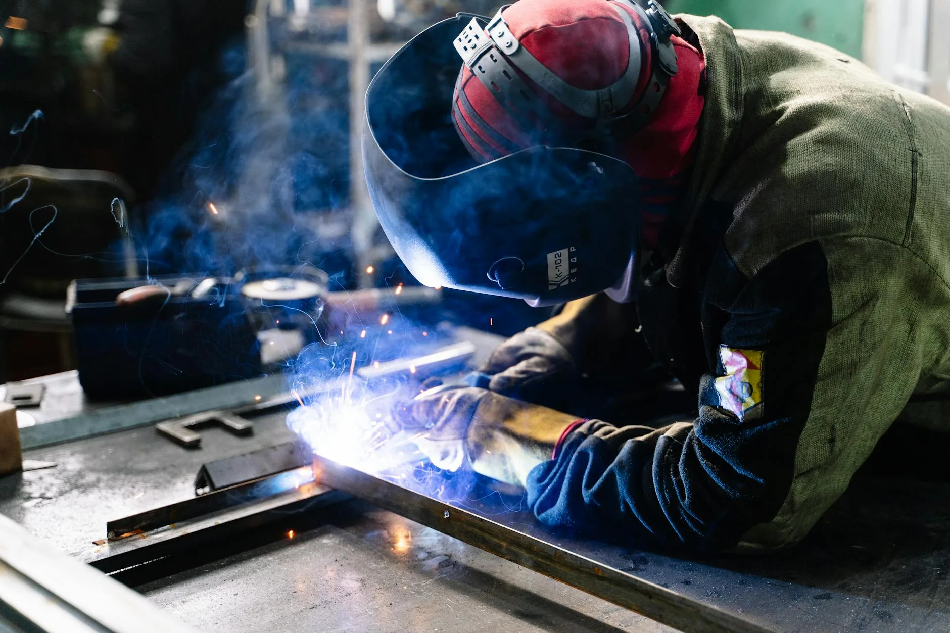 Welding student practicing MIG welding in a training lab