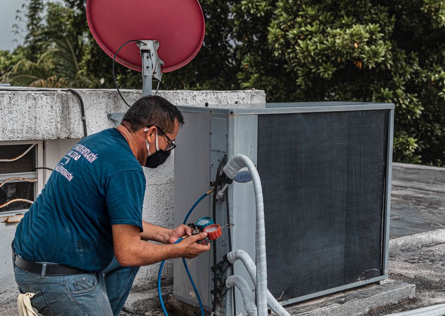 HVAC technician servicing a rooftop unit in Indianapolis